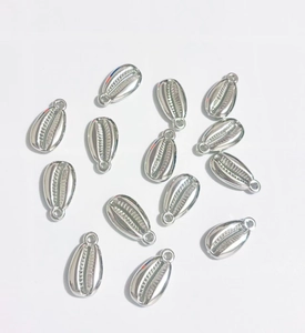 Macro view of silver plated shell pendants for DIY jewelry on a white background
