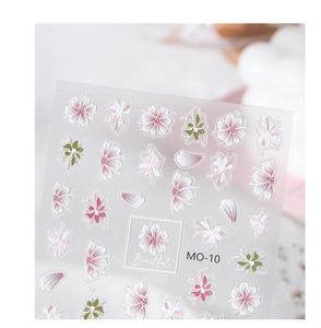 Macro shot of 5D embossed nail stickers with 3D floral textures and hollow designs