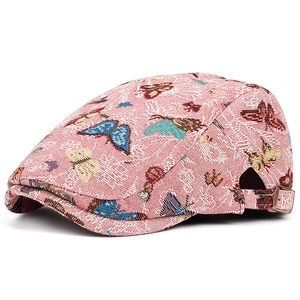 Détail d'une casquette rose avec broderies papillons colorées et boucle en métal réglable