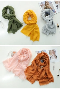 Detail of lightweight solid cotton linen scarves with fringe edges in multi-color options
