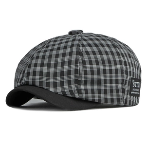 Détail de la casquette gavroche avec motif à carreaux noir et blanc et étiquette latérale