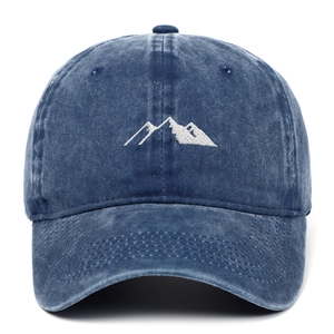 Detail of mountain embroidery on washed navy cotton fabric of a vintage baseball cap