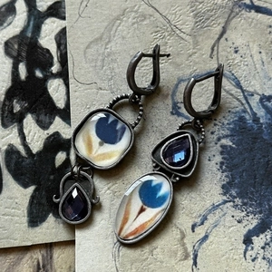 Detail of vintage silver earrings featuring blue tulip enamel and purple gemstones