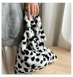 Detail of soft plush tote bag with black and white cow print texture for autumn winter