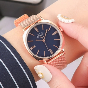 Close-up of elegant rose gold mesh band watch with deep blue crystal indexed dial