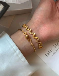 Close-up of 18K gold plated bamboo bracelet with zircon wave bangle on a woman's wrist
