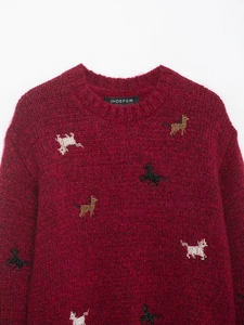 Detail of red mohair knit sweater with colorful animal embroidery and crew neck texture