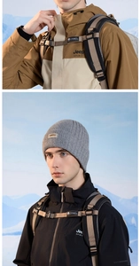 Detailed view of gray ribbed beanie with STUDIO label paired with outdoor jacket and backpack