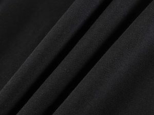 Macro shot of high-quality black knit fabric showing soft texture and fine fiber structure