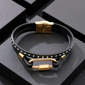 Detail of black double-layered leather bracelet with polished gold stainless steel clasp