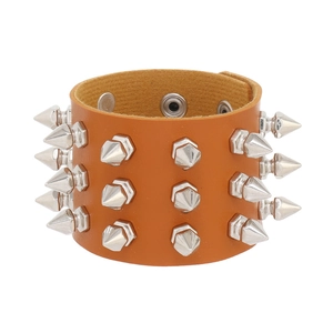 Detail of punk style brown leather bracelet with multiple rows of silver cone spike studs