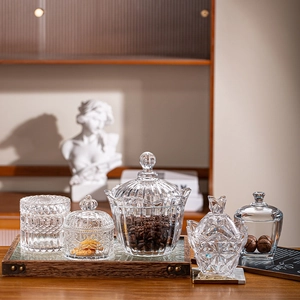 Detailed set of five assorted glass storage jars with lids on a wooden tray
