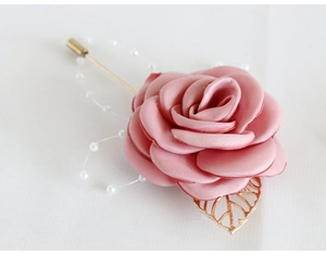 Détail de la broche rose en satin rose poudré avec feuille dorée et perles blanches