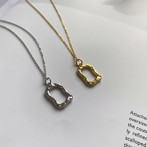 Detail of irregular hammer textured rectangle pendants in gold and silver finishes