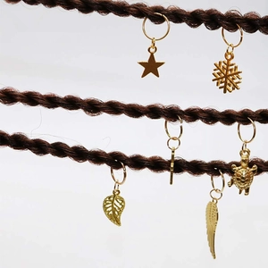 Close-up of golden charms like stars and leaves on braided hair accessories set