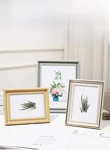 Close-up of modern ivory and gray photo frames with nature art for home decor