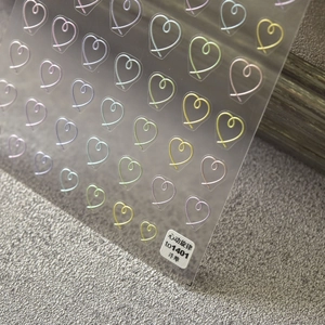 Macro detail of 5D embossed heart nail stickers showing vibrant colors and 3D textures