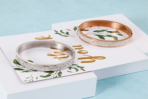 Détail de joncs en or rose et argent avec diamants sur un coffret cadeau élégant