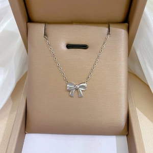 Silver bow pendant necklace presented in a luxury jewelry box with white silk fabric