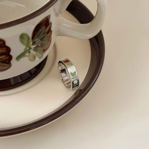 Detail view of 925 silver open ring with enamel red rose and white daisy patterns