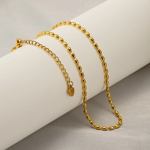 Goldene Edelstahl-Halskette mit ovalen Reisperlen und Herzanhänger auf Display