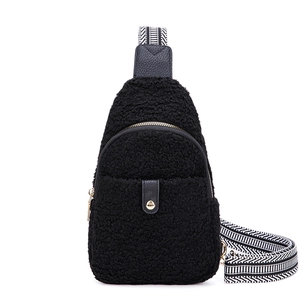 Detail of black faux shearling belt bag with geometric pattern strap and metal zipper