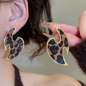 Close-up of leopard print hollow metal earrings with gold frame in a wavy flame design