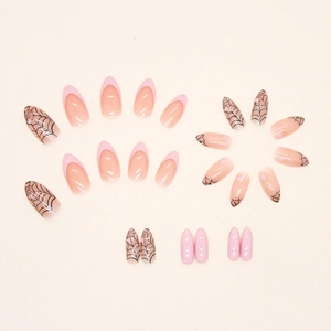 Almond-shaped French press-on nails with pink edges, black spider web designs, and heart accents