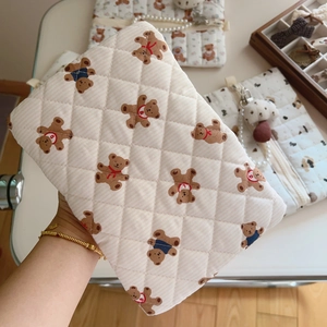 Detail of cute bear printed quilted cotton pouch featuring fine diamond stitching textures