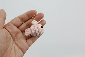 Detailed view of hand-crocheted clownfish keychain in pink and white striped yarn