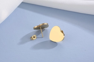 Détails des boucles d'oreilles cœur dorées avec fermoir papillon et finition polie brillante