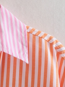 Detail of colorful striped shirt showing precise stitching and pink-orange cotton texture