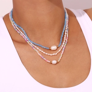 Three-layer beaded necklace with freshwater pearls and colorful seed beads on a model