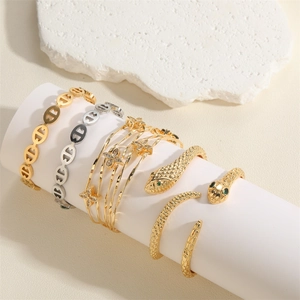 Detail view of gold and silver snake rings and link bracelets on a display stand
