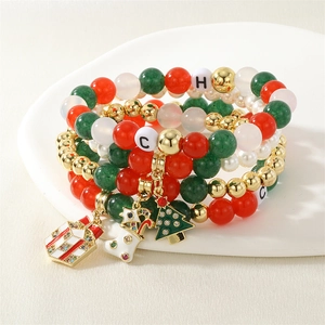 Detail of Christmas beaded bracelets with red, green, and white charms on a plate