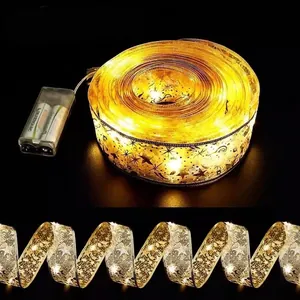 Golden Christmas ribbon LED string lights with star patterns for festive tree decoration
