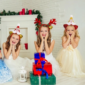 Three children wearing sequined reindeer antlers and Santa hat headbands at a party