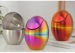 Three egg-shaped stainless steel mini bins in silver, rainbow, and orange gradient finish