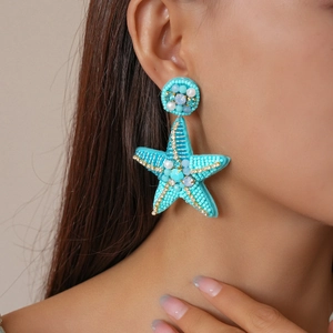 Elegant blue starfish beaded earrings with pearls and crystals shown on model