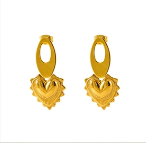 Détail de boucles d'oreilles cœur en titane doré avec texture soleil rayonnante