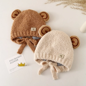Plush baby winter hat with bear ears and earflaps in brown and beige colors