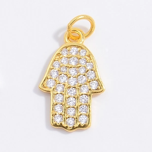 Macro shot of gold plated Hamsa Hand charm with sparkling cubic zirconia pavé stones