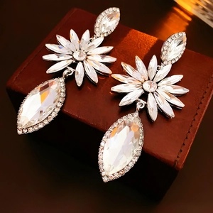 Gros plan de boucles d'oreilles fleuries étincelantes avec gouttes en cristal marquise