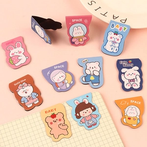 Nahaufnahme süßer Cartoon Magnet-Lesezeichen in Pastellfarben auf rosa Grund