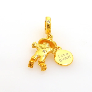 Golden scarecrow pendant with white crystals and Love Guard tag on white background