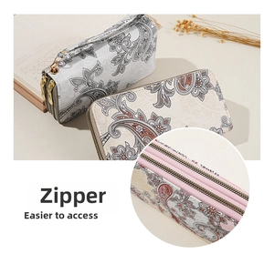 Close-up of dual zipper long wallet with floral paisley pattern and wrist strap