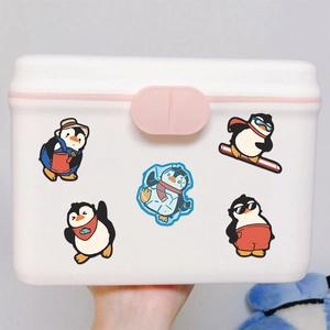 White storage box with pink latches decorated with five cute cartoon penguin stickers