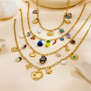 Detailed view of gold multi-layered necklace with seashell, starfish and sun charms