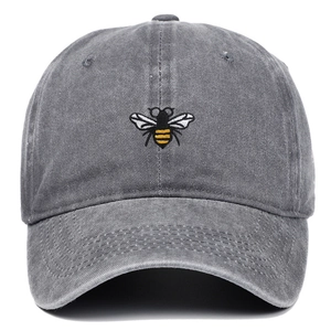 Gros plan de la broderie d'abeille et texture gris lavé sur une casquette de baseball