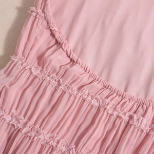 Detailed view of pink pleated fabric with delicate lace patchwork on backless dress
